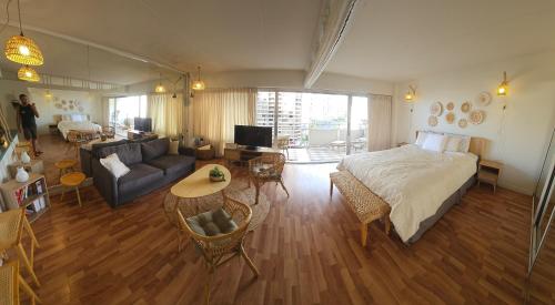 a bedroom with a bed and a living room with a couch at Ilikai luxury suites - unit#1123 in Honolulu