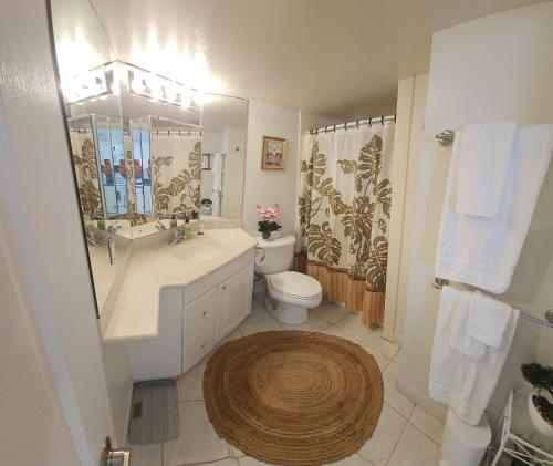 a bathroom with a sink and a toilet and a mirror at Ilikai luxury suites - unit#1123 in Honolulu