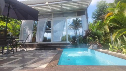 a house with a swimming pool and an umbrella at Cabañas Los Tulipanes in La Mesa