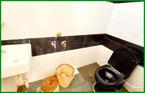 a bathroom with a black toilet and a sink at Mahakaleshwar jyotilinga Temple Dwarika - Dhish Premium near Railway station, Fully Air conditioned Rooms -wifi- Lift and Restaurant Facilities, BEST HOTEL IN UJJAIN in Ujjain