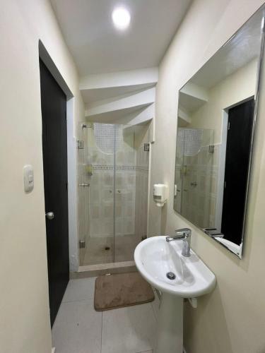 a bathroom with a sink and a shower with a mirror at Ebratt Inn in Cartagena de Indias