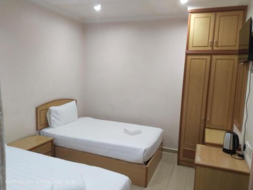 ein kleines Zimmer mit zwei Betten und einem Schrank in der Unterkunft BBHotel in Gerik