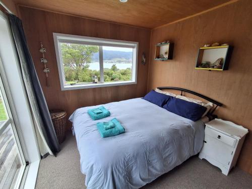 a bedroom with a bed with blue towels on it at Tairua Getaway in Tairua