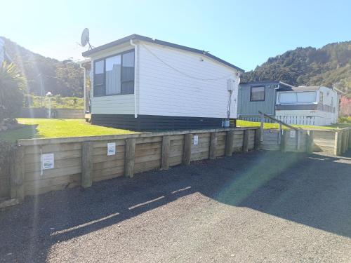 a house with a fence in front of it at Riverview Studio in Te Puru