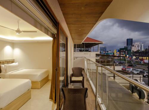 a hotel room with a balcony with a view of the city at Olwen Suites in Cochin