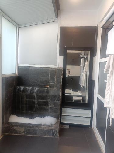 a bathroom with a stone shower with a mirror at Amazing Valley View in Kasauli