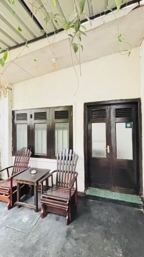a patio with two chairs and a table and a table and two windows at chula,s Home Stay in Matara