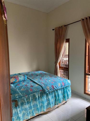 a bedroom with a bed and a window at Serayu Jaraksari Homestay in Wonosobo