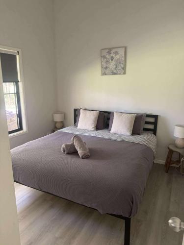 a bedroom with a large bed with two pillows at Rural Self Contained 3 bedroom Cottage on acreage, in Landsborough