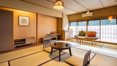 a large living room with a table and chairs at Hakkei in Maniwa