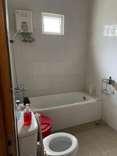 a bathroom with a toilet and a bath tub at Serayu Jaraksari Homestay in Wonosobo