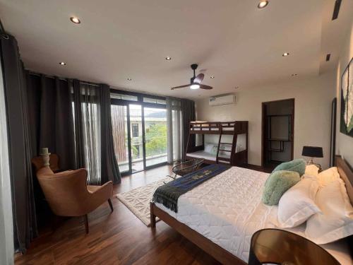 a bedroom with a bed and a chair and windows at Tahum Lake Resort in Los Baños