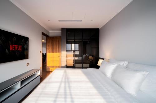 a bedroom with a large white bed and a tv at Duc Hoang Residence West Lake in Hanoi