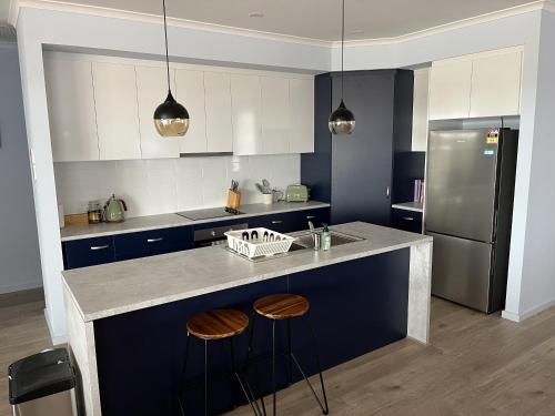 a kitchen with a counter with stools and a refrigerator at Pelicans Perch in Mannum