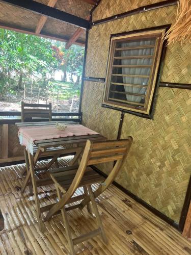 a table and a chair on a screened in porch at ocam ocam cottages in Busuanga