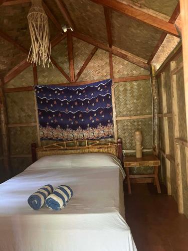 a bedroom with a bed in a wooden room at ocam ocam cottages in Busuanga