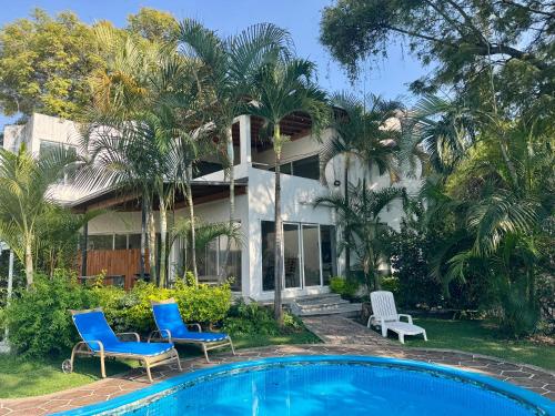 a house with a swimming pool in front of a house at Casa con Alberca y terraza un lugar tranquilo para disfrutar in Cuernavaca