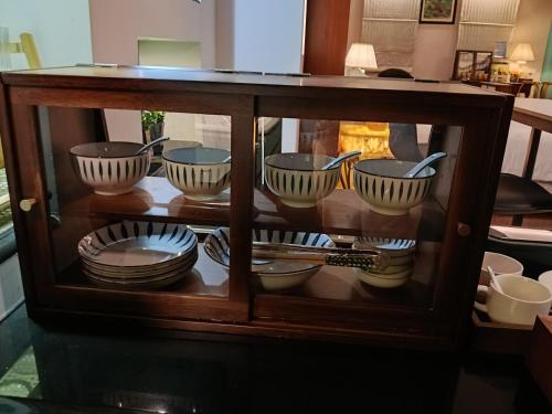 a display cabinet filled with bowls and plates at Grand Pool Villa Luxury Resort Port Dickson in Port Dickson