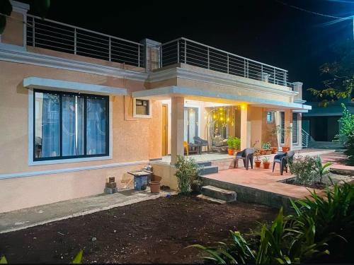 Sea view villa في Harnai: منزل كبير مع فناء في الليل