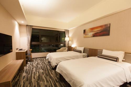 a hotel room with two beds and a television at The Fuli Resort Chihpen in Taitung City