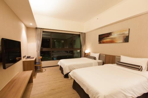 a hotel room with two beds and a television at The Fuli Resort Chihpen in Taitung City