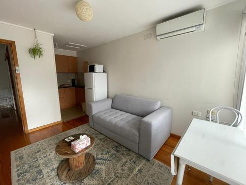 a living room with a couch and a table at Gippsland Getaway in Moe