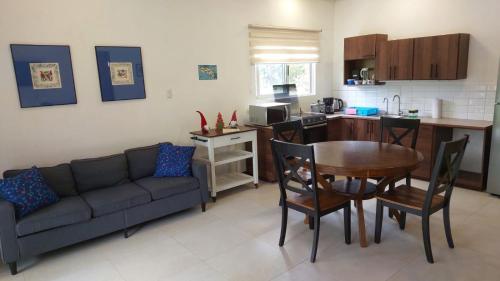 een woonkamer met een bank en een tafel en een keuken bij Villas Pura Vida - Mango in Puntarenas