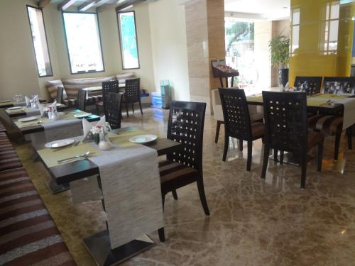 a dining room with tables and chairs in a restaurant at Ascot Hotel in Mumbai