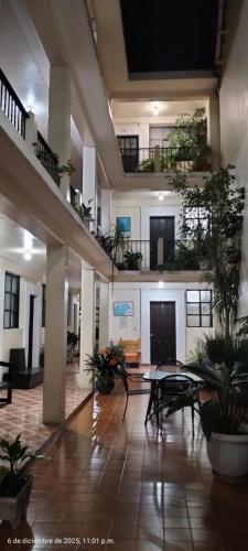 a large room with tables and plants in a building at Hotel San Martin in San Cristóbal de Las Casas