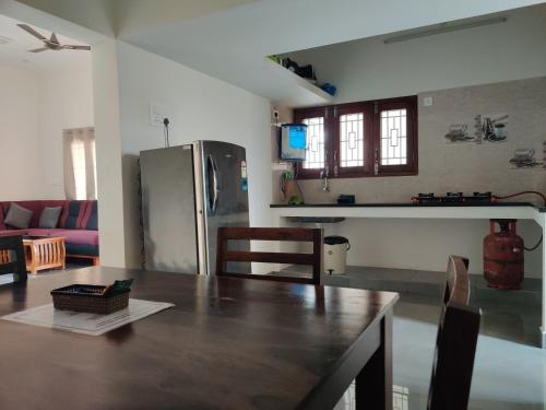 a kitchen and living room with a wooden table at Meadow View in Tiruvannāmalai