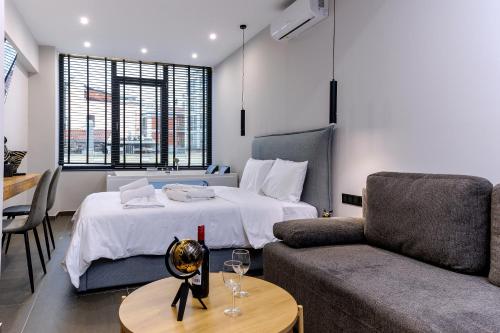 a hotel room with a bed and a couch at Timeless luxury suites & SPA in Thessaloniki