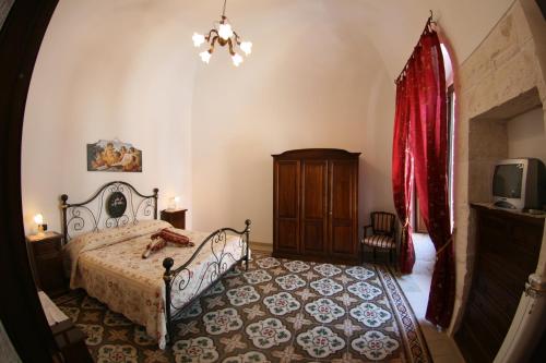 a bedroom with a bed and a tv in a room at L'Angolo Antico in Castellana Grotte