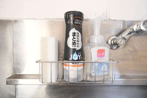 een metalen plank met toiletartikelen erop in een badkamer bij 駅近商業施設近くで便利 静かで心ほぐれる滞在が叶う宿neuk Hill 定員5名 無料駐車場有 in Fukuroi