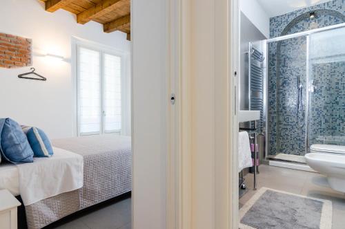 sypialnia z łóżkiem oraz łazienka z umywalką w obiekcie Milano Porta Venezia w Mediolanie