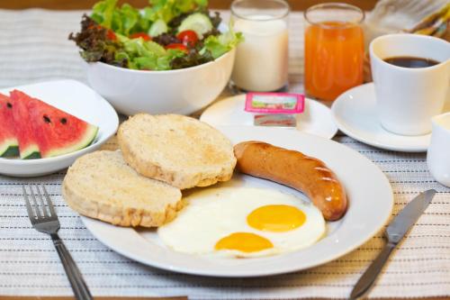 a breakfast plate with eggs and bread and a salad at At Ease As Home in Chiang Mai