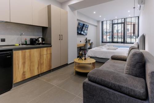 a kitchen and a living room with a couch and a bed at Timeless luxury suites & SPA in Thessaloniki