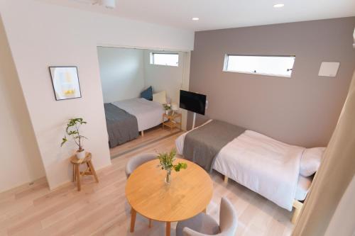 a bedroom with a bed and a table in a room at Sion NAGOYA in Nagoya