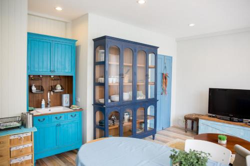 a kitchen with blue cabinets and a blue hutch at fio's house by the sea in Cha Am