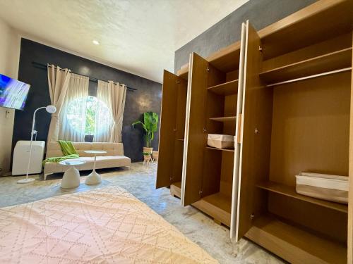 Habitación con cama, sofá y ventana en Departamento Belembi merida, en Mérida