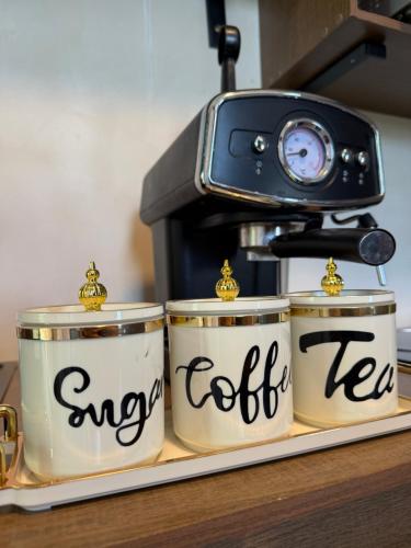 Una cafetera y tres latas de café en un mostrador. en Departamento Belembi merida, en Mérida