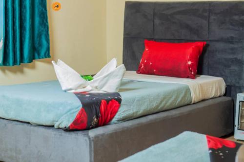 a bed with red and white pillows on it at Villa guest house in Ndola