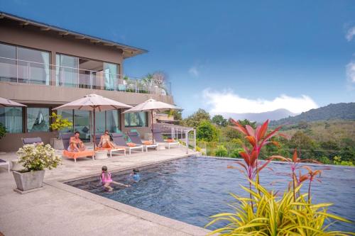 a house with a pool with people in it at Tropical Castle Villa in Phuket