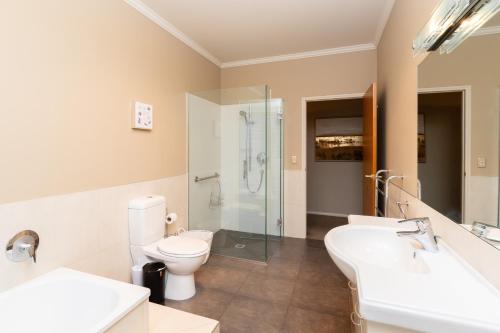 a bathroom with a toilet and two sinks and a shower at Beacon Point Lakeview Escape - Spacious - Stylish in Wanaka