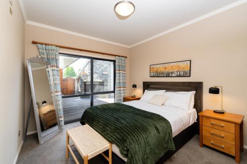a bedroom with a bed and a large window at Beacon Point Lakeview Escape - Spacious - Stylish in Wanaka