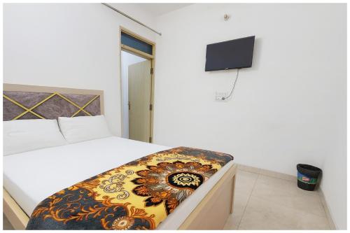 a bedroom with a bed and a tv on the wall at Surya Nagar Hotel M - Residency Near Baba Ji Gurudev Mandir- Sri Krishna Janmabhoomi - Room Service and Parking facilities - Fully Air conditioning Luxuary Room - Top Rated Hotel In Mathura in Mathura