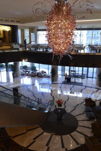 a large lobby with a chandelier in a building at Wyndham Grand Istanbul Europe in Istanbul