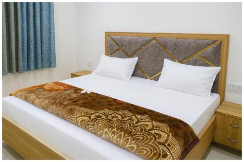 a bedroom with a large bed with a wooden headboard at Surya Nagar Hotel M - Residency Near Baba Ji Gurudev Mandir- Sri Krishna Janmabhoomi - Room Service and Parking facilities - Fully Air conditioning Luxuary Room - Top Rated Hotel In Mathura in Mathura