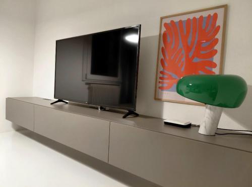 a living room with a tv and a green chair at Villa Maria in Onno