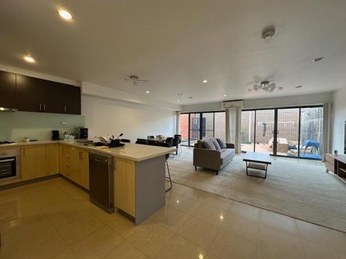 a large kitchen and living room in a house at A cozy room with ensuite in Springvale, in a shared accommodation in Springvale