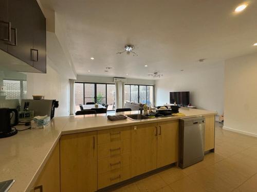 a kitchen with wooden cabinets and a counter top at A cozy room with ensuite in Springvale, in a shared accommodation in Springvale
